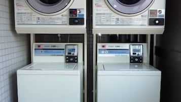 Two stacked washing machines in a narrow space.