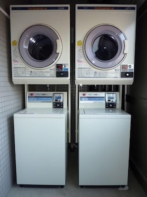 Two stacked washing machines in a narrow space.