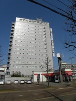 Un edificio hotelero alto y moderno con varios pisos y una fachada uniforme.
