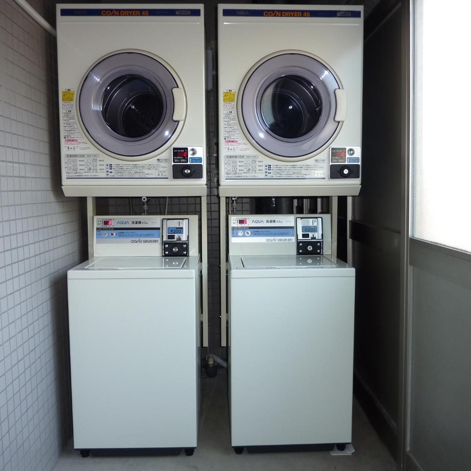 Deux machines à laver à chargement frontal, superposées, dotées de panneaux de commande et d’un écran numérique.