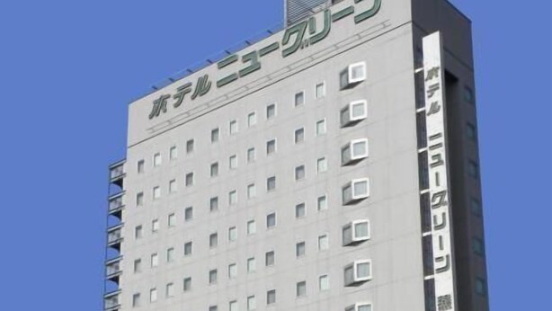 A tall, modern hotel building with a grid of windows and balconies.