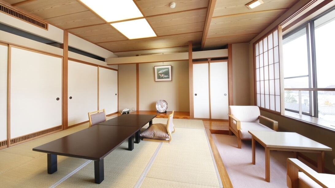 Ein traditioneller japanischer Raum mit Tatami-Böden, einem niedrigen Tisch und verschiebbaren Türen.