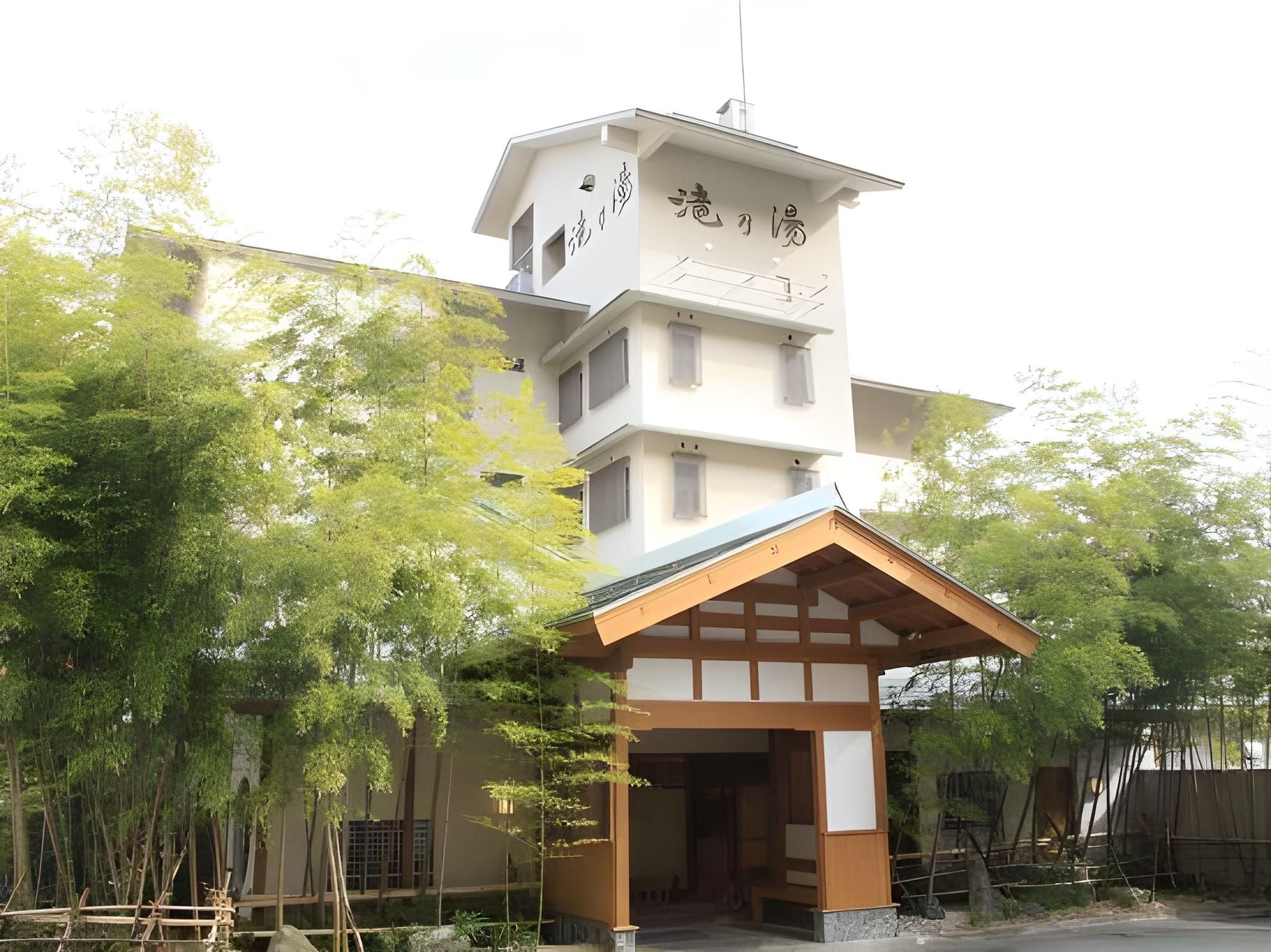 A multi-story building with a traditional Japanese architectural style, featuring a prominent entrance with a wooden overhang.