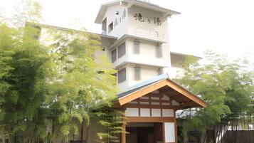 A multi-story building with a traditional Japanese architectural style, featuring a prominent entrance with a wooden overhang.