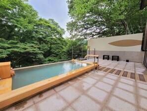 An outdoor swimming pool with a wooden deck, surrounded by lush greenery. - Shiobara Onsen Okushiobara Kogen Hotel (Nasushiobara)