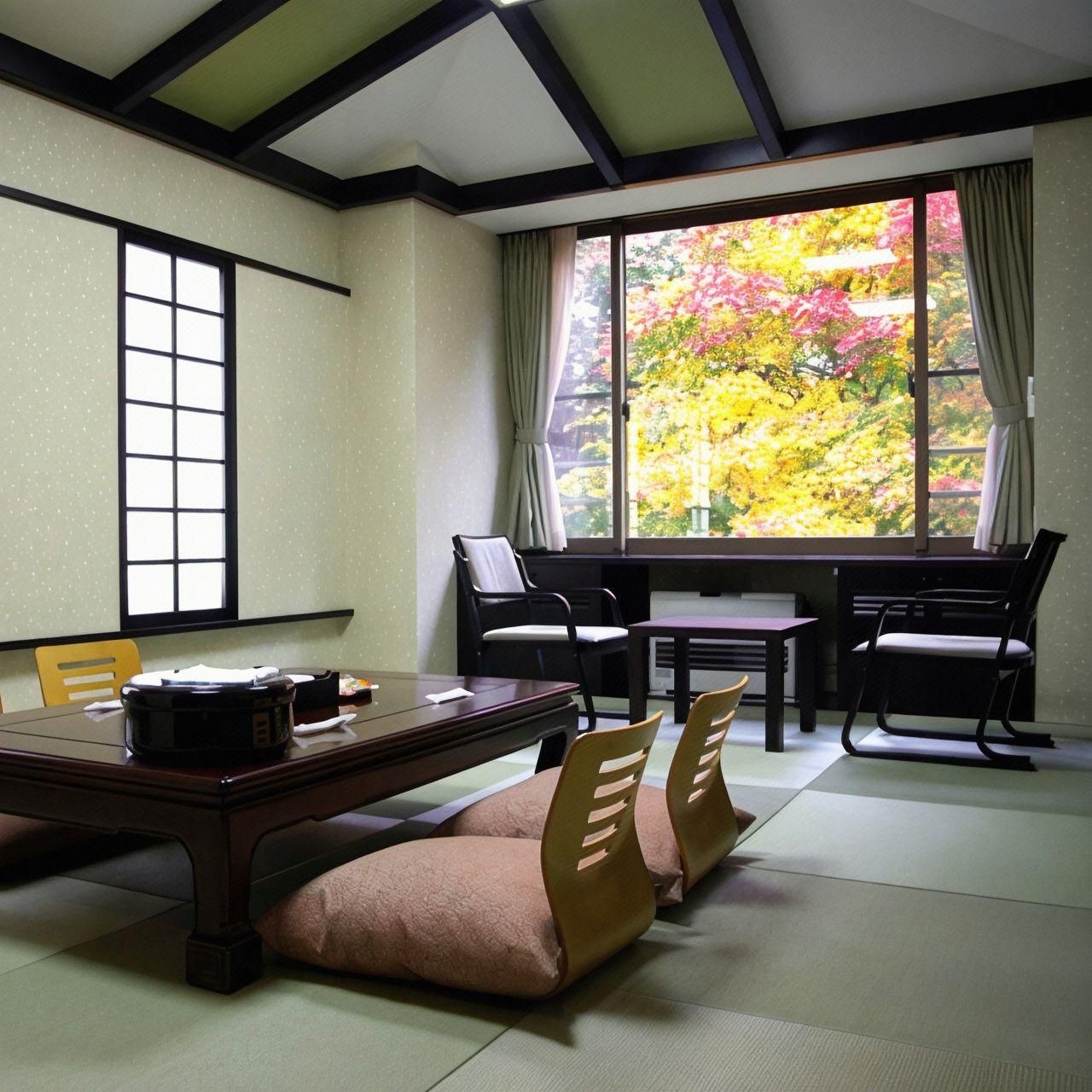A traditional Japanese-style room with tatami flooring, a low table, and chairs.