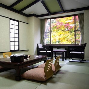 A traditional Japanese-style room with tatami flooring, a low table, and chairs. - Shiobara Onsen Okushiobara Kogen Hotel (Nasushiobara)