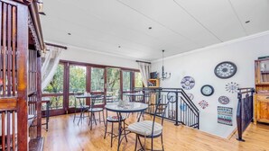 A spacious room with a wooden floor, large windows, and a staircase. - 42onKing (Centurion)