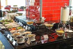 A buffet with various food items and a coffee station.