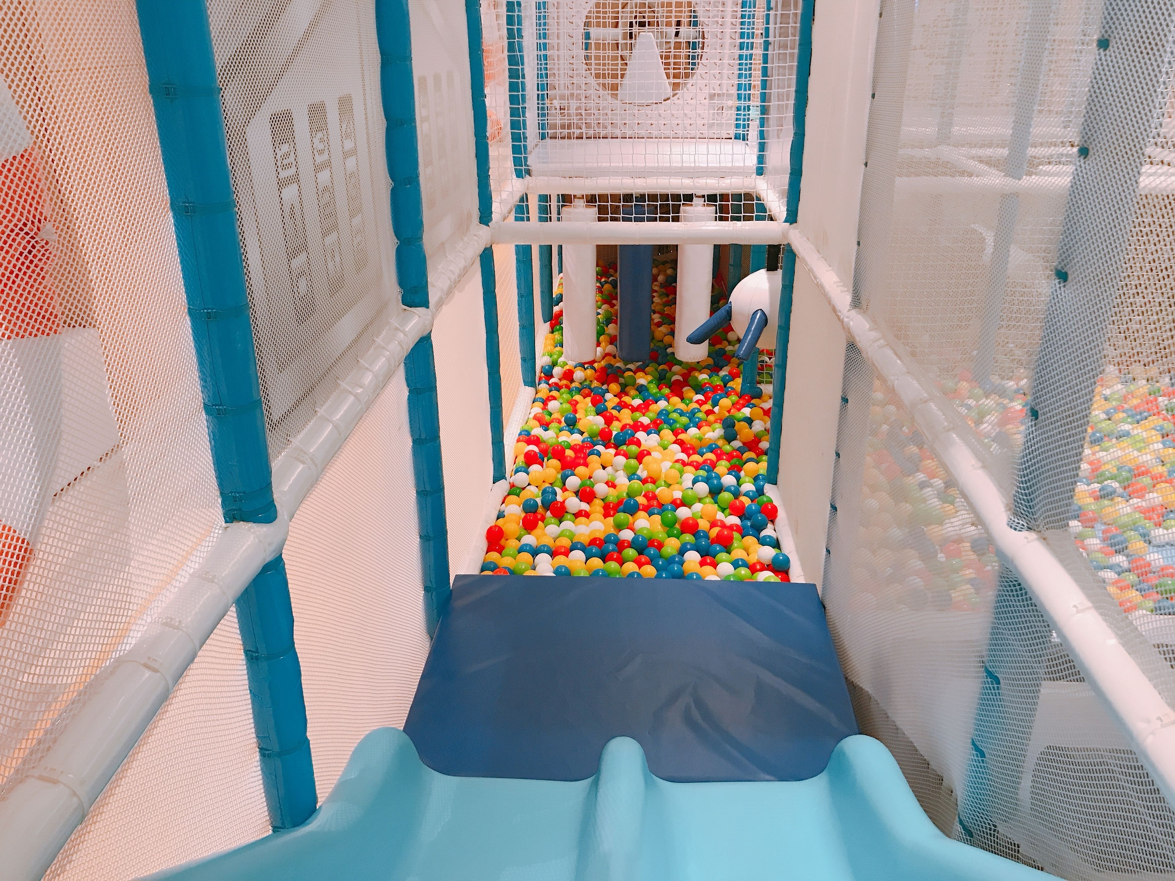 Een speelruimte met een glijbaan en een ballenbak.