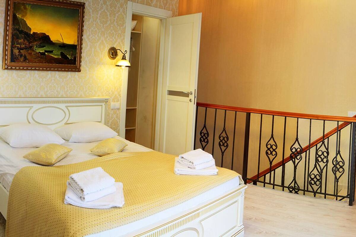 A hotel room with a bed, a bathroom, and a staircase.