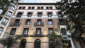 Un immeuble à plusieurs étages, doté d’une façade en briques, de nombreux balcons et d’une entrée au niveau du sol.