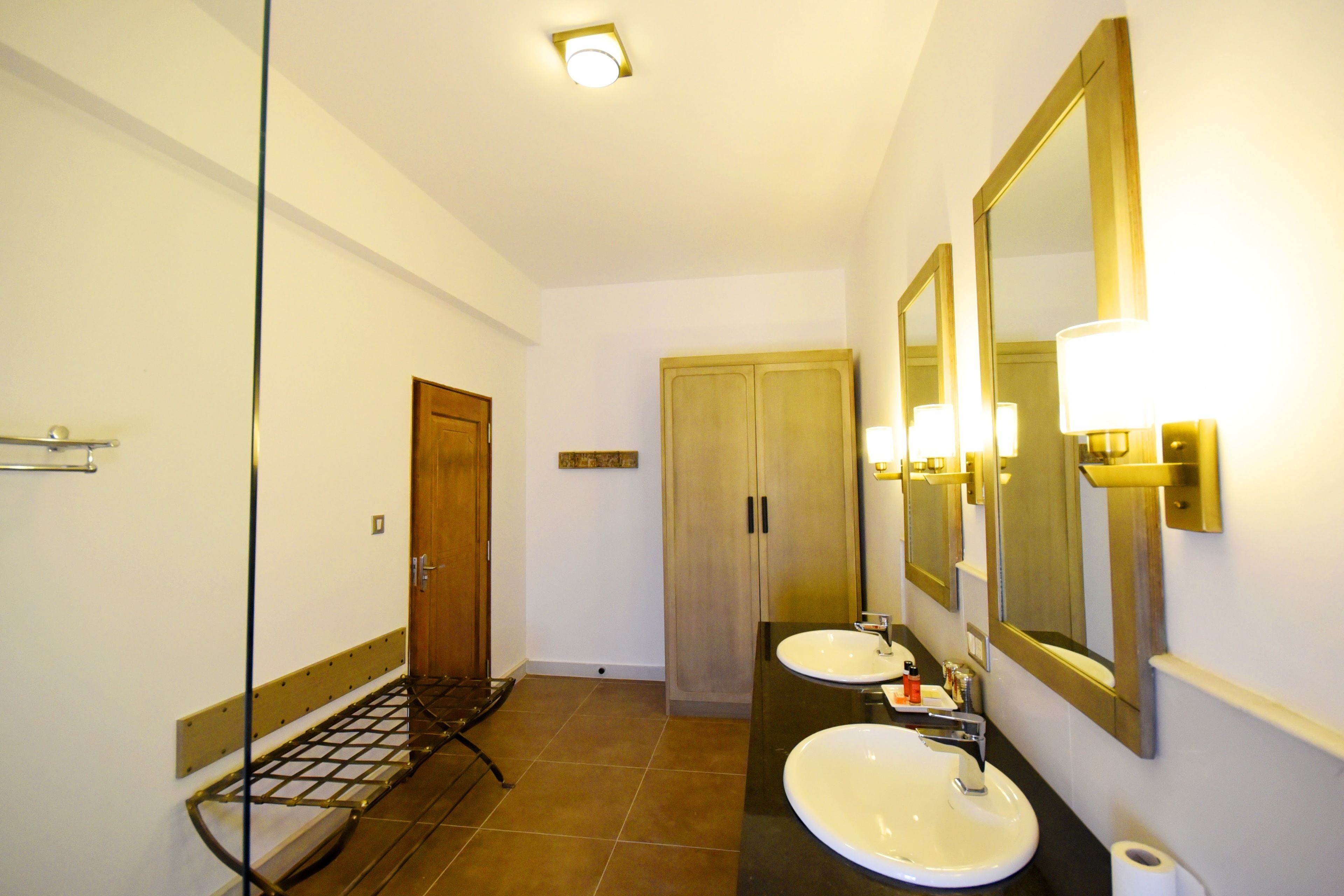 A bathroom with two sinks, a mirror, and a towel rack.