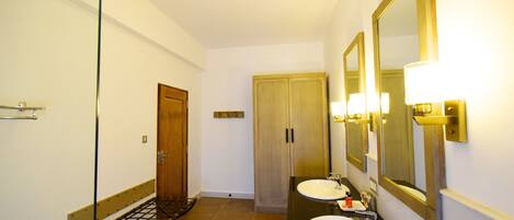 A bathroom with two sinks, a mirror, and a towel rack.