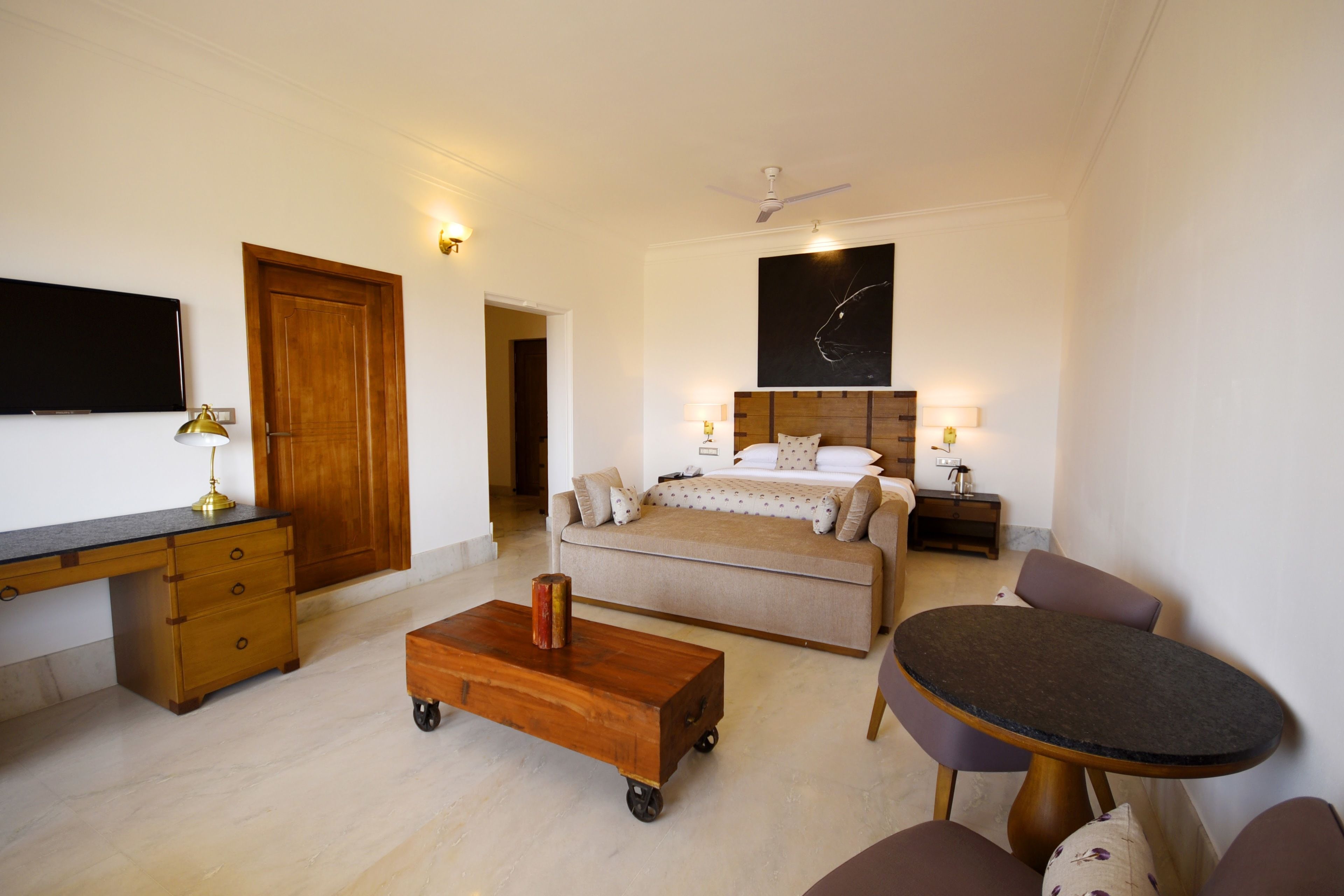 Ein Hotelzimmer mit Bett, Schreibtisch, Stuhl und einem kleinen Esstisch.