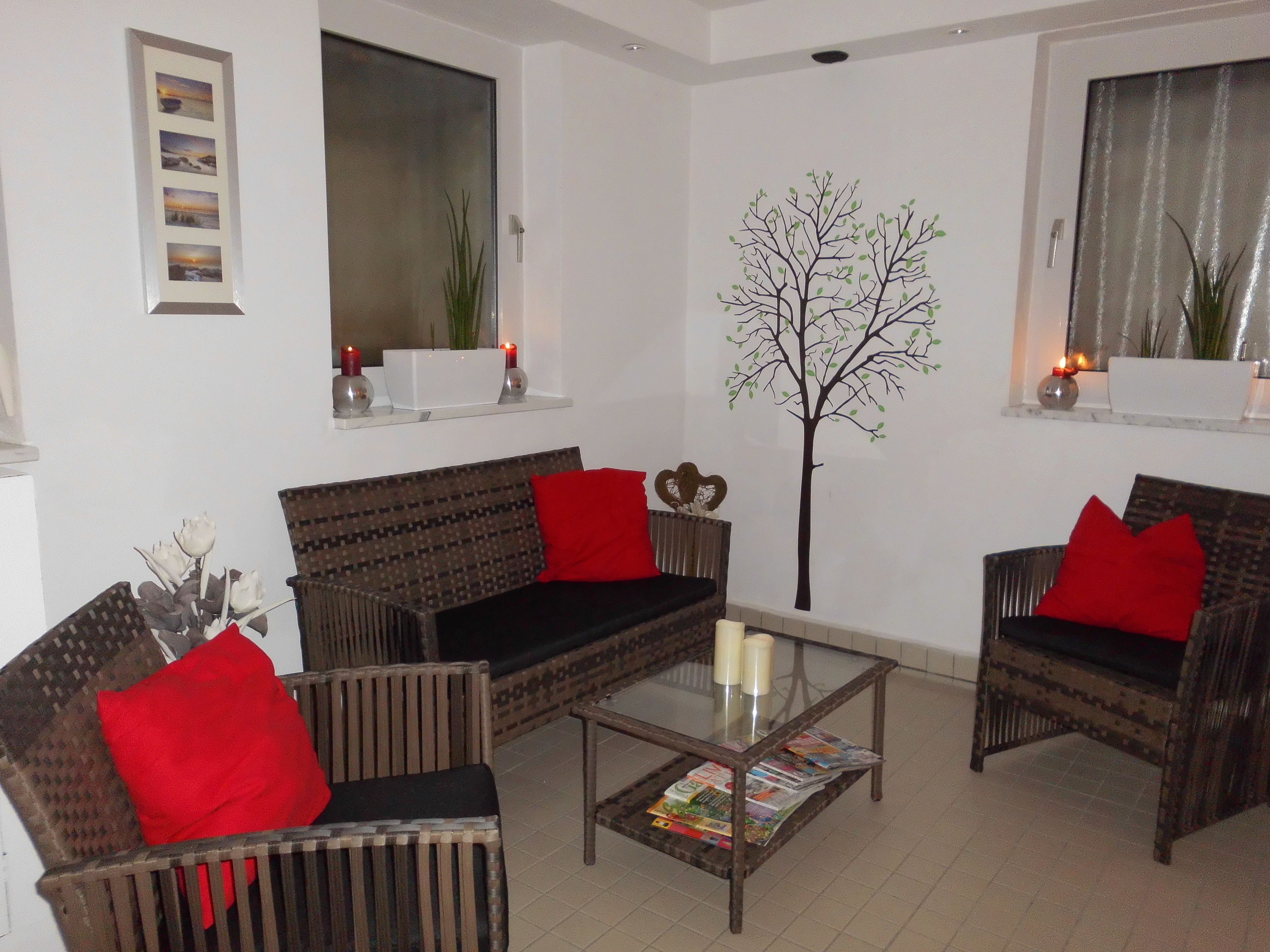 A living room with a sofa, two armchairs, a coffee table, and a decorative tree.