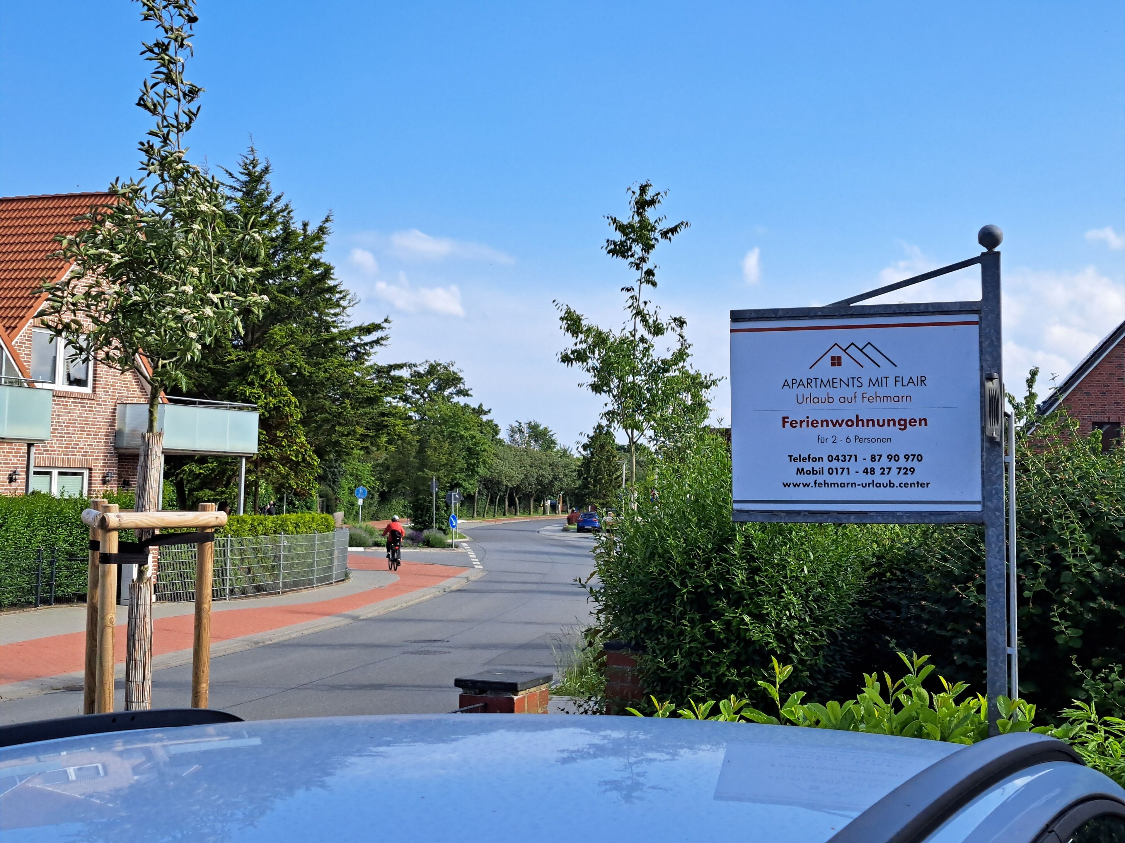 A residential area with a signboard advertising apartments with a view of Fehmarn.