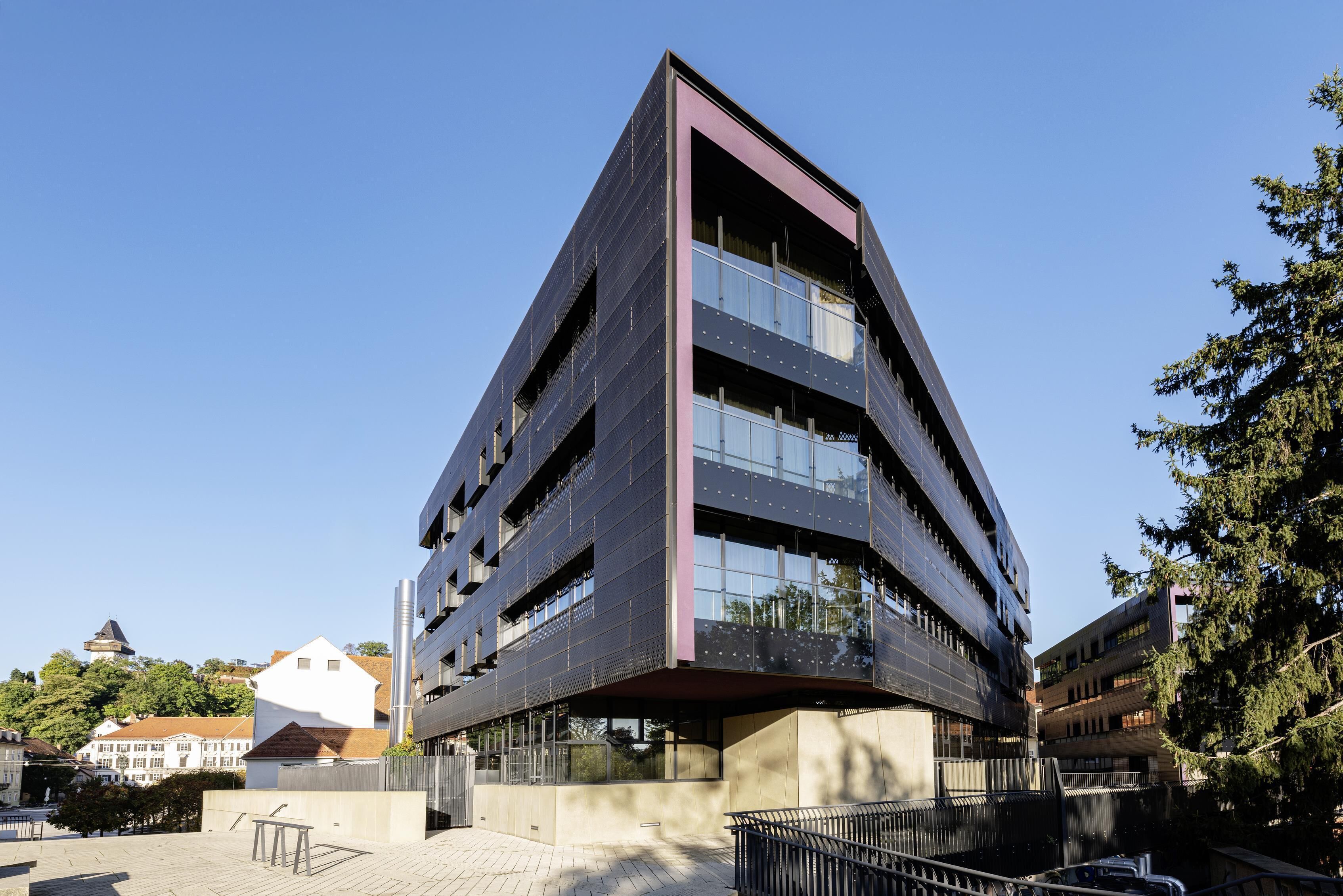 A modern multi-story building with a unique angular design, large windows, and a flat roof.