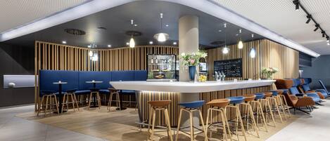 A modern bar area with a curved ceiling, wooden slats, and blue seating.