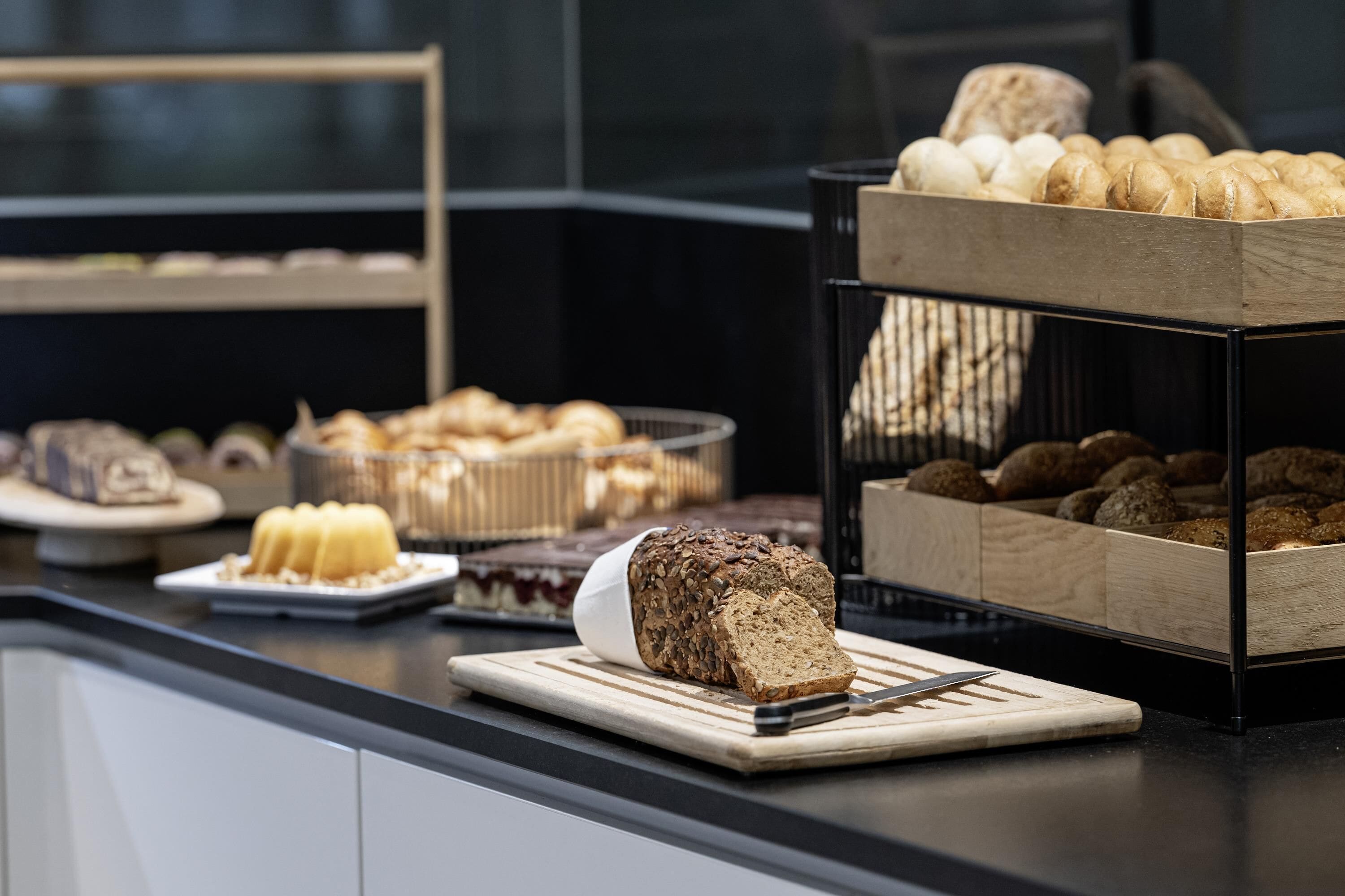 Un buffet proposant une variété de produits de boulangerie, notamment du pain, des petits pains et des viennoiseries.