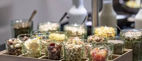 A variety of food items in glass containers on a wooden tray.