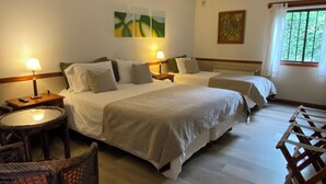 Habitación de hotel con dos camas, una mesa redonda y una silla.