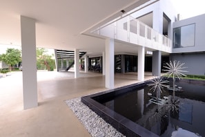 A modern building with a central courtyard featuring a reflective water feature and seating.