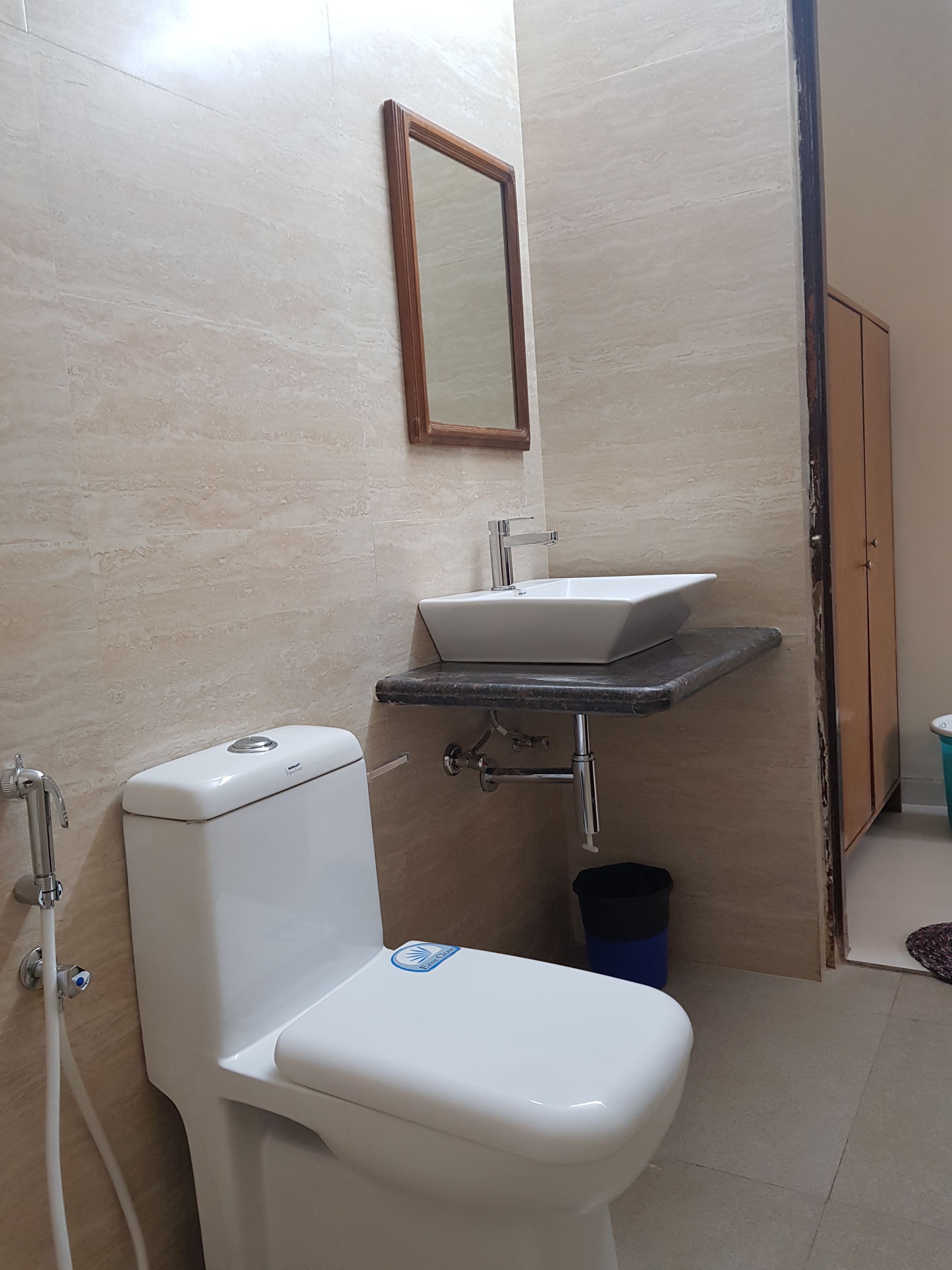 A bathroom with a toilet, sink, and mirror.