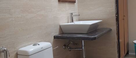 A bathroom with a toilet, sink, and mirror.