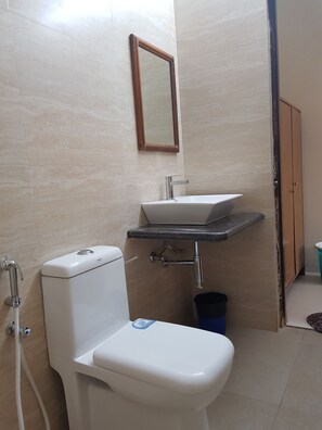 Ein Badezimmer mit Toilette, Waschbecken und Spiegel.