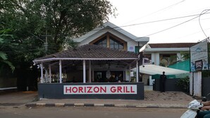 A Horizon Grill restaurant with a covered outdoor seating area and a signboard.