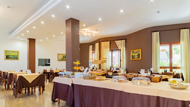 Un espace repas avec plusieurs tables, un buffet et des œuvres d’art accrochées aux murs.