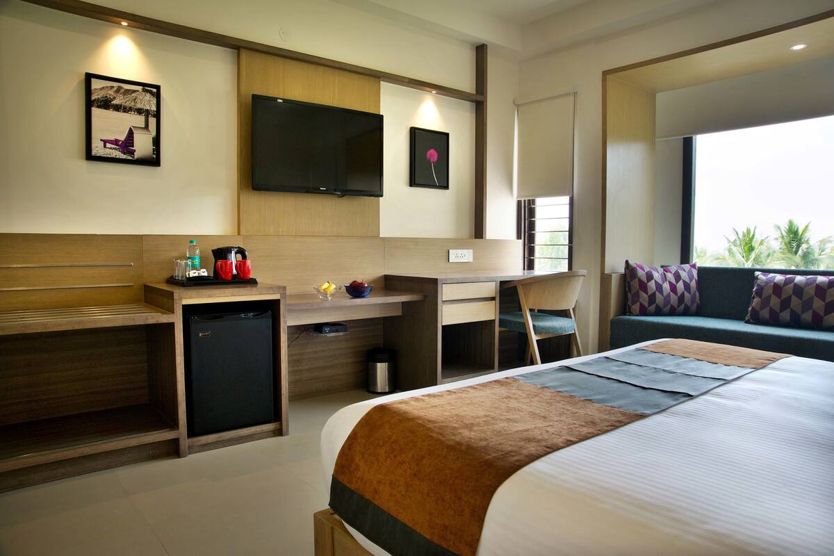 Ein Hotelzimmer mit Bett, Schreibtisch und Sitzgelegenheit.