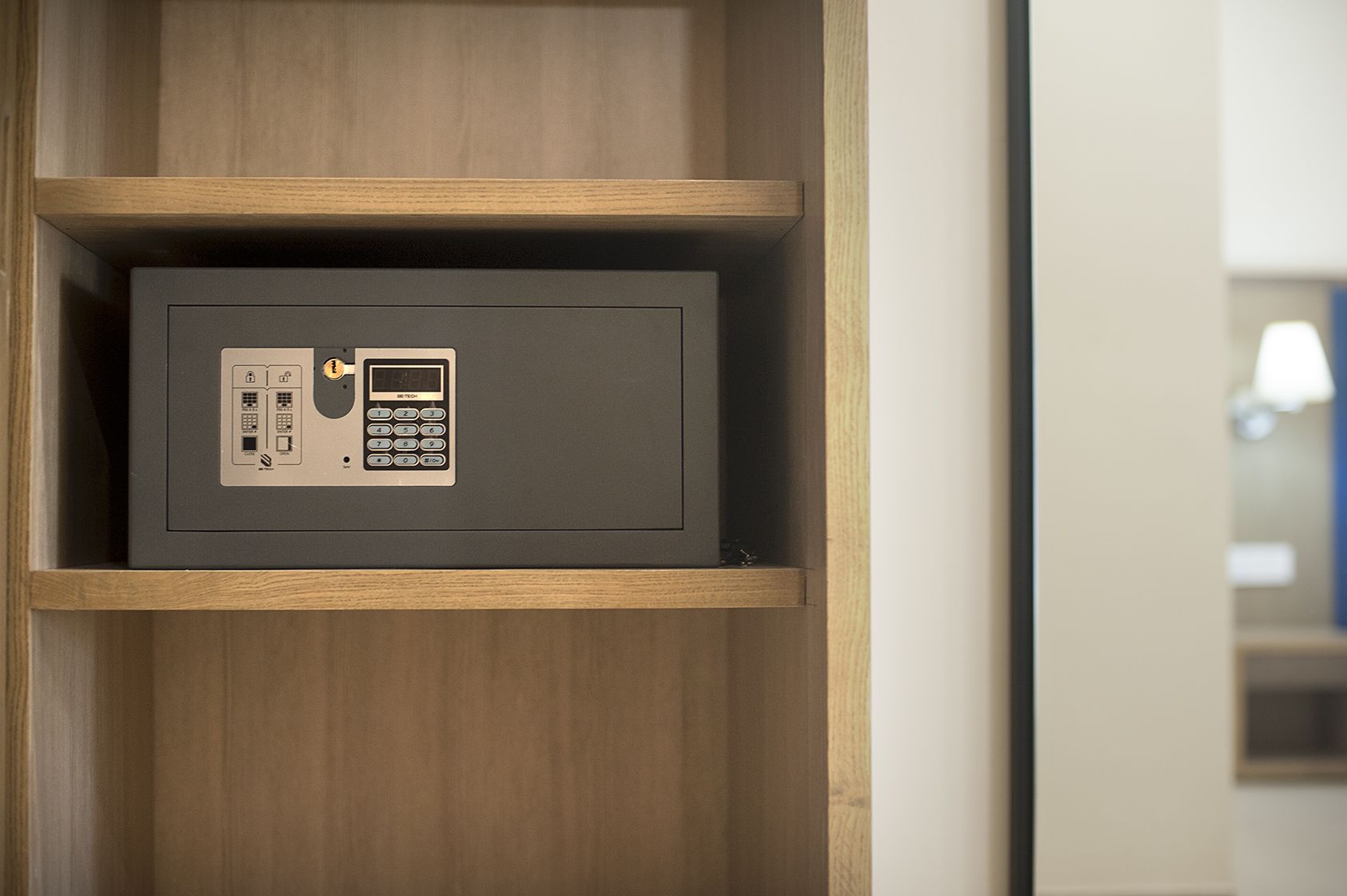 A secure storage unit with a keypad and card slot, housed in a wooden cabinet.