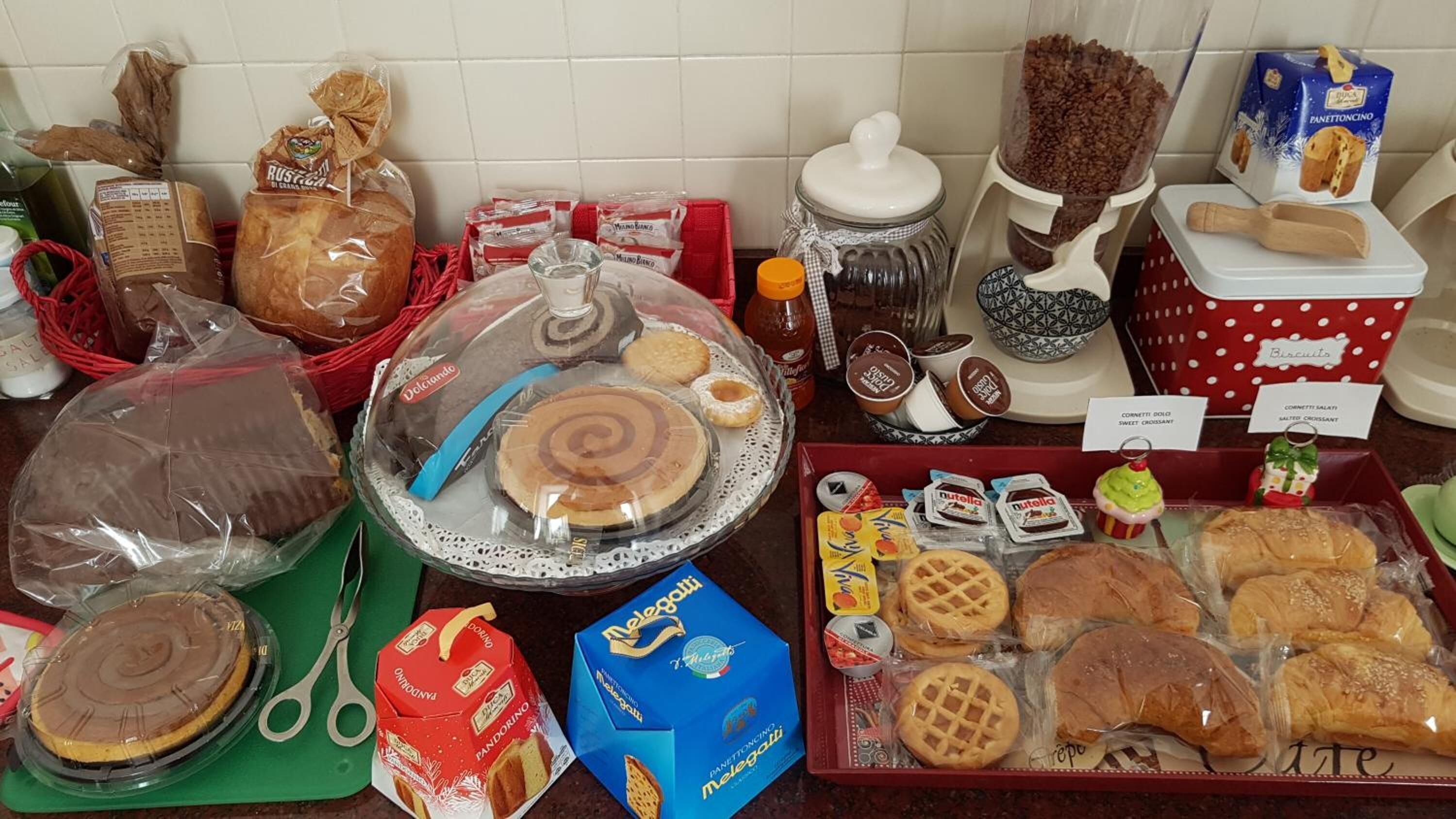 A variety of packaged food items, including bread, pastries, and cookies, displayed on a kitchen counter.