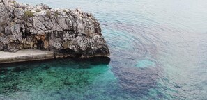 Una costa rocosa con aguas turquesas cristalinas.