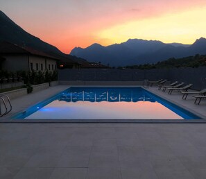 A rectangular swimming pool with a clear blue water surface, surrounded by a tiled deck. - Hotel Merloni (Grandola ed Uniti)