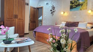 Ein Schlafzimmer mit einem Bett, einem Nachttisch, einem Stuhl und einem Tisch mit Blumen.