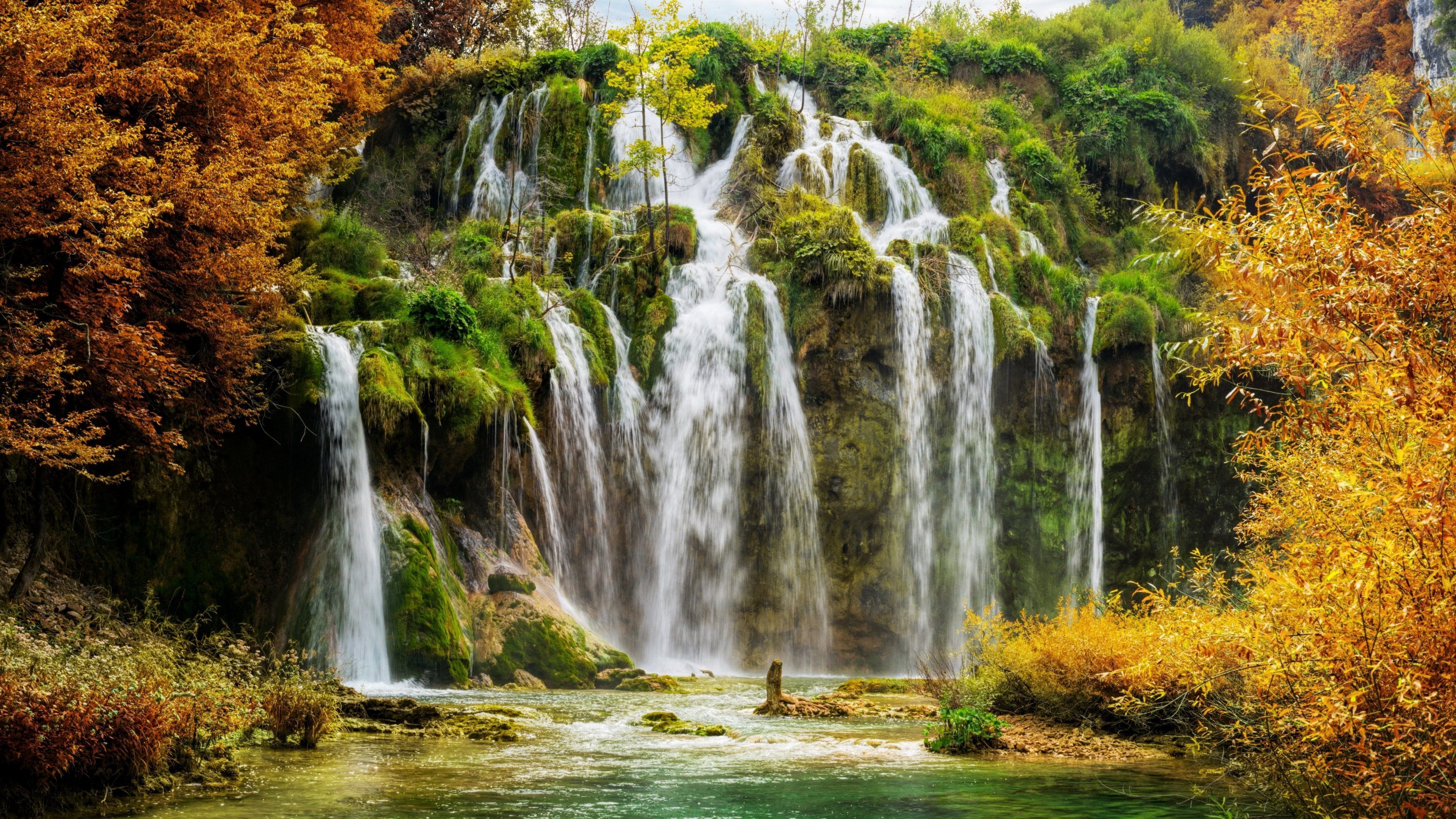 Een waterval omringd door herfstkleuren.