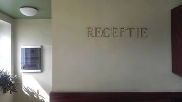 Un área de recepción con un cartel en la pared que dice 'RECEPTION'.
