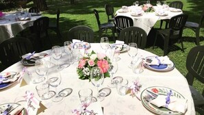 An outdoor dining area with round tables set for a meal, each with plates, cutlery, and glasses. - Villa al Piano (Lastra a Signa)