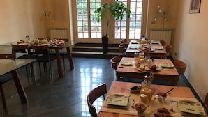 A dining area with tables set for breakfast, including croissants and fruit. - Villa al Piano (Lastra a Signa)