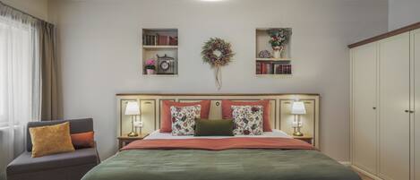 A hotel room with a bed, a chair, a bookshelf, a wardrobe, and a ceiling light.
