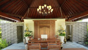 A wooden dining table with chairs, a chandelier, and decorative vases. - Bali Paradise Heritage by Prabhu (Ungasan)