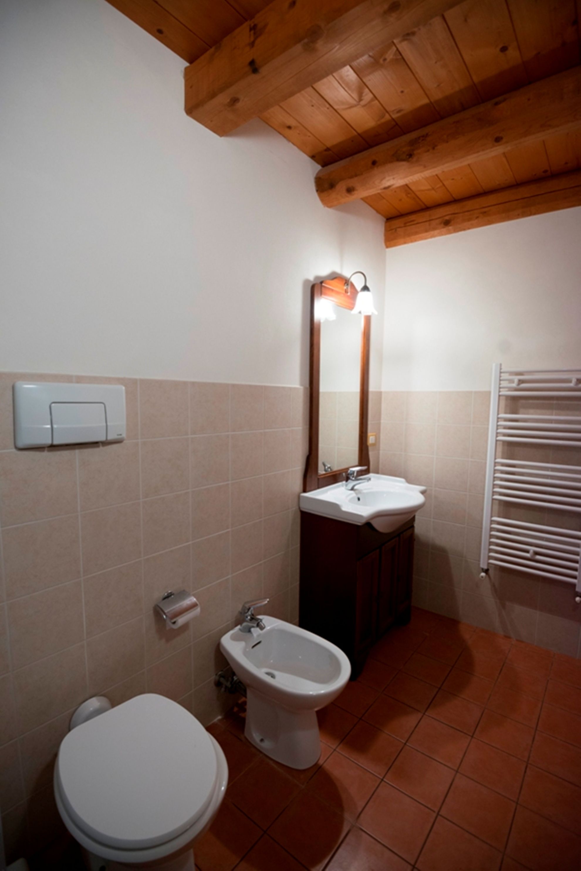 Ein Badezimmer mit Toilette, Bidet, Waschbecken und Handtuchhalter.