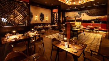 A restaurant with multiple dining tables, chairs, and a wine rack.