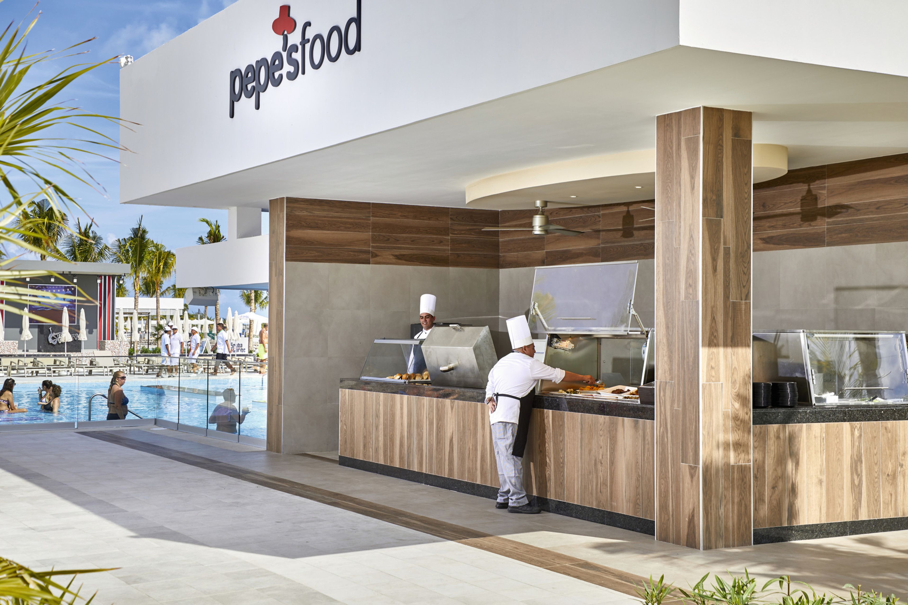 A food kiosk with a wooden counter and a clear view of the pool area in the background.