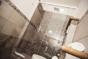 A bathroom with a glass-enclosed shower, a toilet, and a towel rack. - Mirabilia Guest House (Rome)