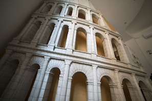 A detailed architectural model of a classical building with multiple arches and columns. - Mirabilia Guest House (Rome)