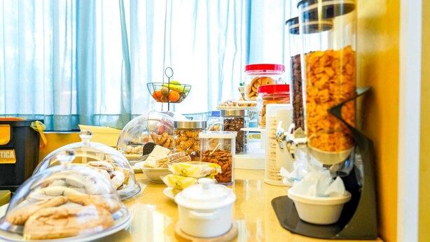 A buffet with various food items, including pastries, fruits, and nuts, displayed in clear containers and bowls. - Motel - Hotel Nautico Pozzallo (Pozzallo)